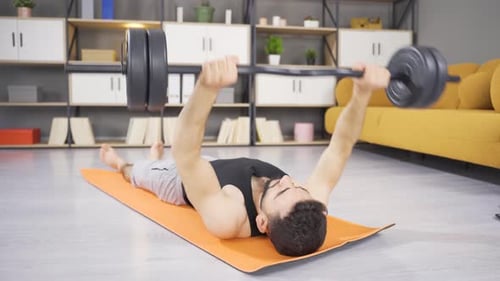 Man Lifts Barbell at Home for Exercise
