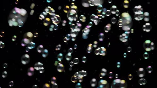 Superposition de bulles de savon colorées volant sur fond noir