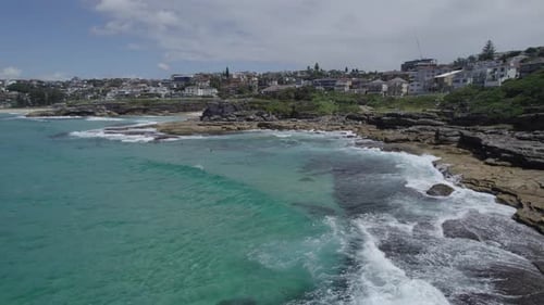 Waves Crashing On The Rocky Shore Of Tamarama Point In New South Wales, Australia. Aerial Drone Shot