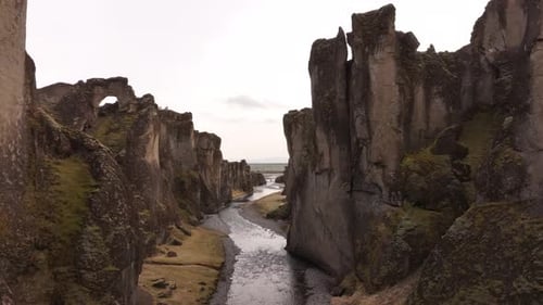 aerial - dramatic cliffs and winding river in Fjaðrárgljúfur canyon Iceland