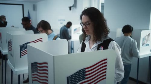 Woman in Glasses Votes in Booth in Polling Station Office