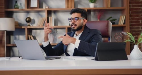 Professional Man Video Conferencing at Desk