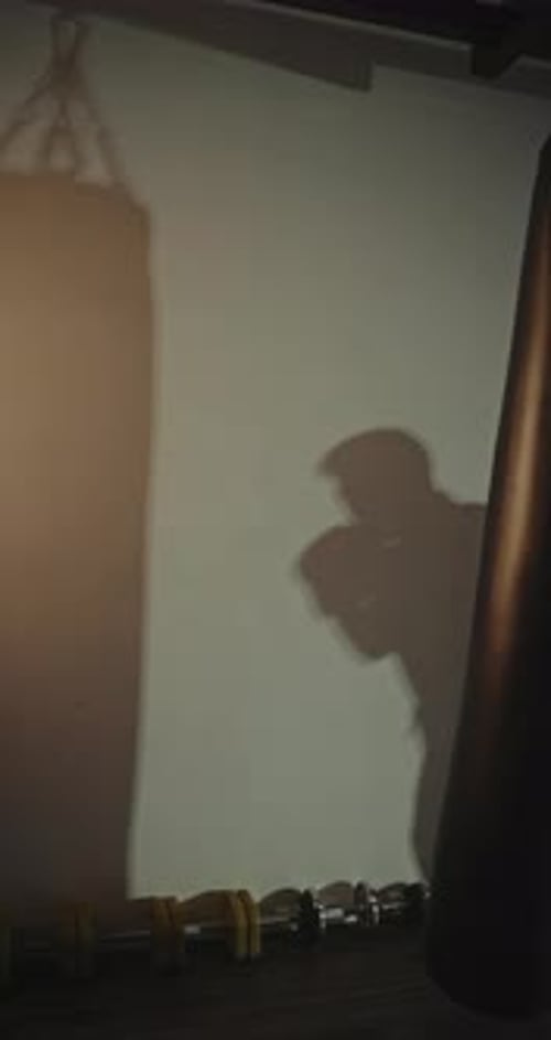 Man Boxing in Dark Gym