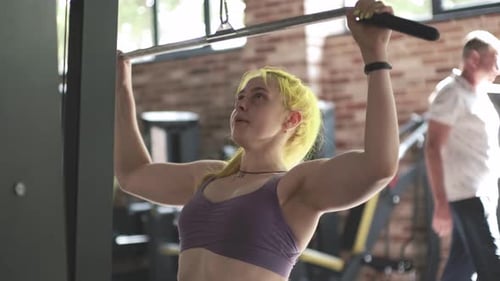 Gorgeous Female Professional Bodybuilder Doing Workout Exercises in Gym