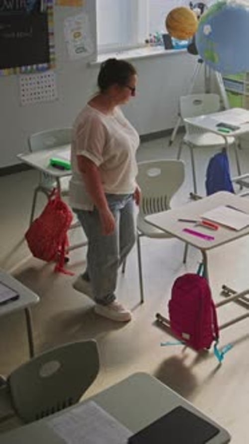 Tired Female Teacher Sitting Alone in Empty Classroom Relaxing After Class