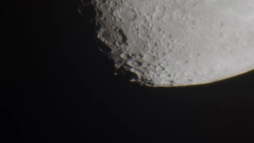 Extreme close up of the moon entering frame from above, through some atmosphere