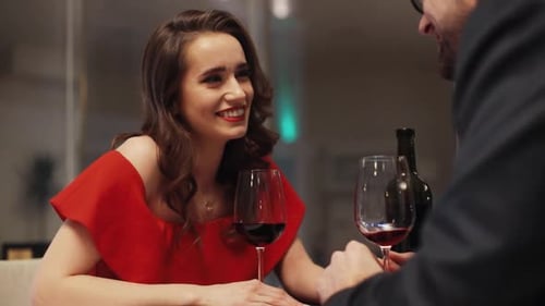 Young Couple in Love Sitting at Table Drinking Wine Handsome Man with Beard Sitting in Front of
