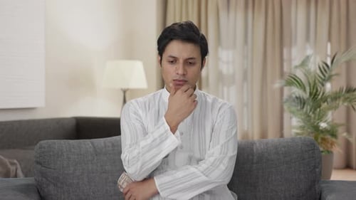 Man Counting Money on Couch Indoors