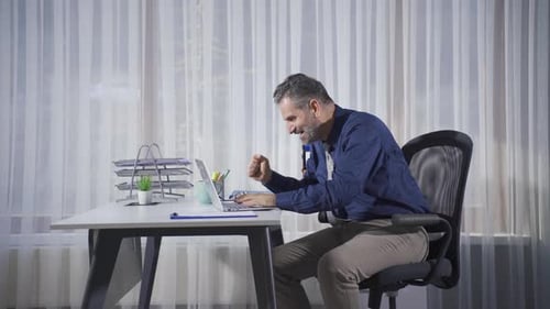 Excited Businessman Celebrating Success at Computer