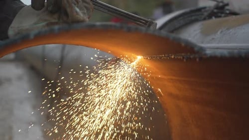 Gloved Hand Using Gas Torch to Cut Metal Pipe