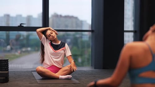 Young Women Stretching in a Modern Gym