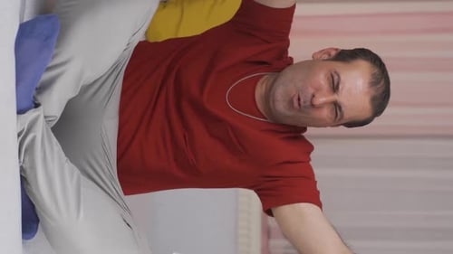 Man Sitting Opening Shopping Bags Indoors