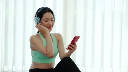 Woman Listens to Music on Headphones in Home