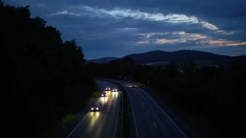 Timelapse footage of a german autobahn, highway at night, filmed of a bridge with small mountains in