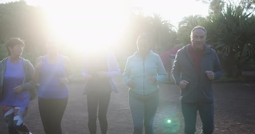 Senior people running at city park - Group of elderly friends doing sport workout together outdoor