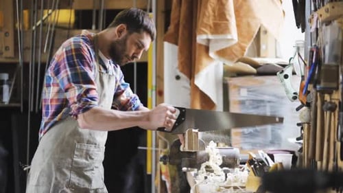 Profession, People, Carpentry, Woodwork and People Concept - Carpenter Working with Saw