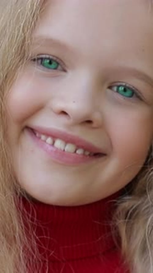 Une fille joyeuse aux yeux verts capture la joie dans une tenue rouge confortable