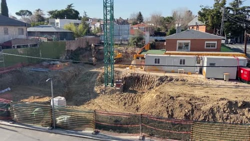 Cimentaciones de edificios excavadas en un sitio de construcción vacío con una grúa