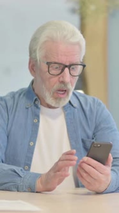 Senior Man Surprised by News on Smartphone