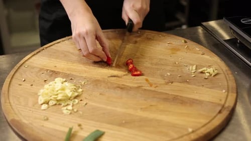 Chef Chopping Chilies on Wooden Cutting Board