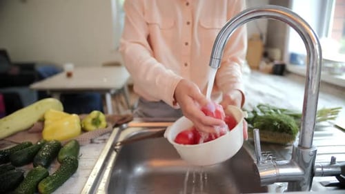 Woman Washing Fresh Tomatoes in Kitchen Sink