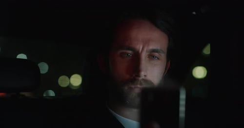 Slow motion of young handsome businessman in car using a smartphone for futuristic and technologic