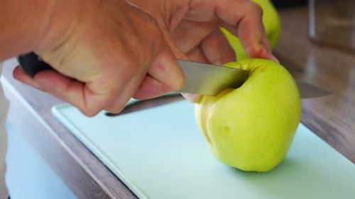 Close Up View of Hand of Man Preparing Apples for a Healthy Juice or Smoothie in Home Kitchen
