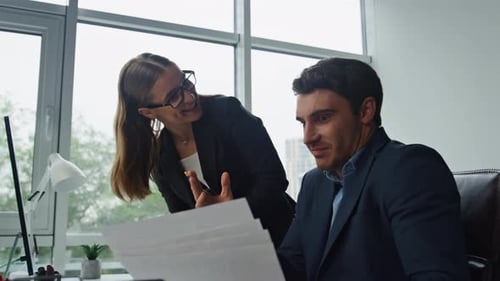 Smiling business team working together in office on project with computer