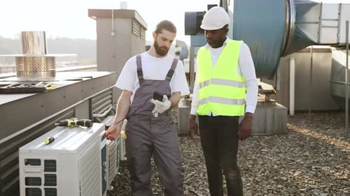 Men Workers Measuring Voltage of Conditioner on Factory