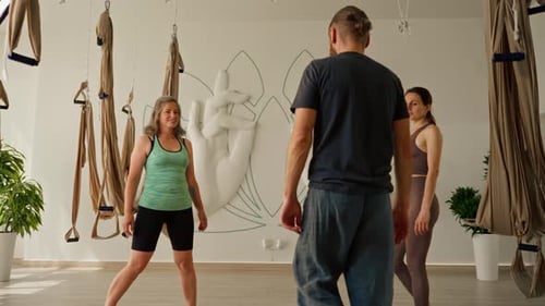 Three People Do Yoga Tree Pose Indoors