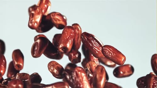 Dates Falling in Slow Motion Against White Background