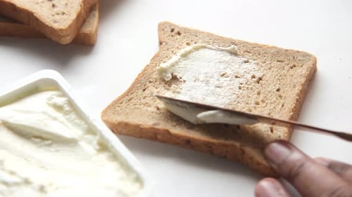 Spreading Cream Cheese on Wheat Bread with Knife