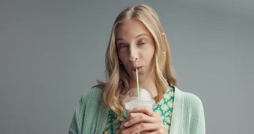 Woman, smoothie and face with smile in studio for drink, health and wellness with straw by