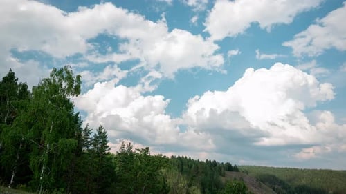 Rolling Clouds Over Lush Forested Hills