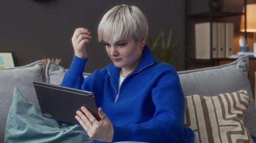 Young Adult Using Tablet on Comfortable Sofa