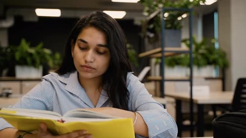 Young Indian Student Woman Reading a Book in the Library