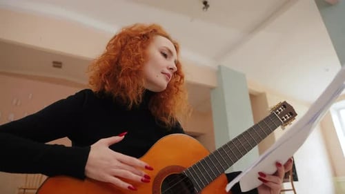 Woman Plays Guitar and Sings Indoors