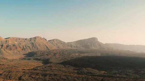 Desert volcanic landscape in red. Stones and a mountain with a volcano.