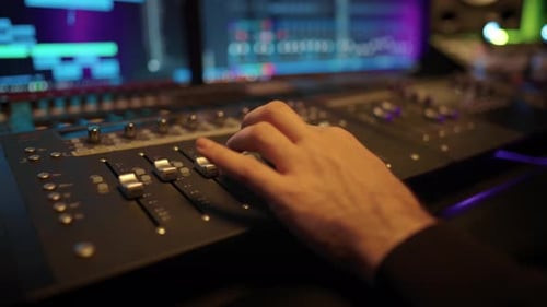 Closeup of Soundman Hand Adjusting Music Mixer in Record Studio Music Industry Recording Soundtrack