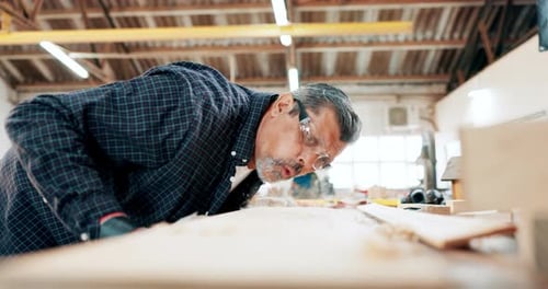 Man, woodwork and blow sawdust in workshop for furniture manufacturing for small business