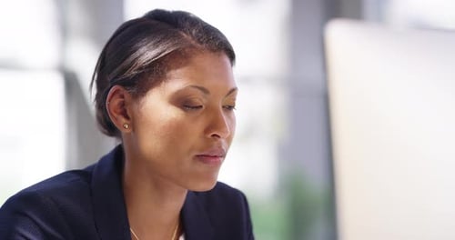 4k video footage of an attractive young businesswoman working on a desktop in her office