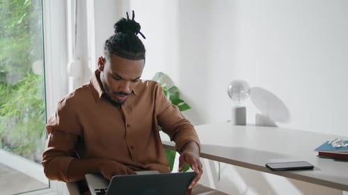 Man working on laptop in modern apartment