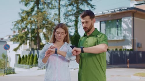 Couple Checking Smart Watches After Outdoor Workout