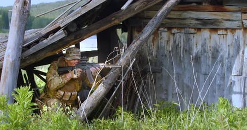 Soldier aiming rifle from inside dilapidated wooden structure