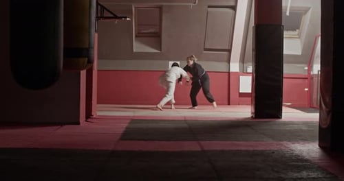 Two People Sparring in a Martial Arts Dojo
