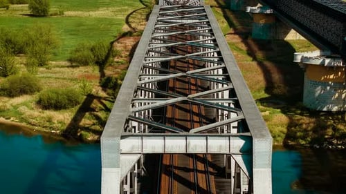Eisenbahnbrücke überquert Fluss auf dem Land Eisenbahnbrücke aus Metall, die sich über das Wasser erstreckt