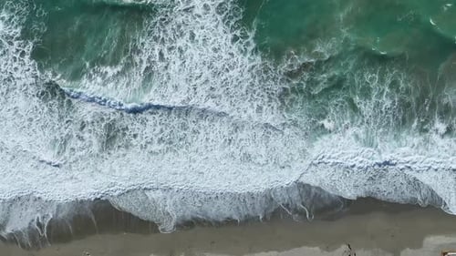 Vue aérienne de vagues puissantes avec des rayons du soleil qui scintillent et se reflètent dans l'eau de mer verte