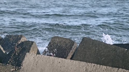 Rompeolas de hormigón. Splash de agua en Pier Rock. Un chorrito de agua sobre el concreto
