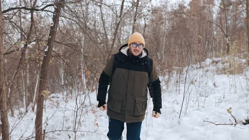 Man Walking in a Snowy Forest in Winter