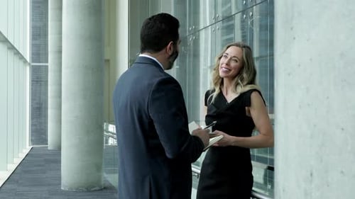 Businessman and Businesswoman Talking and Drinking Coffee in Office Corridor 4044 Years